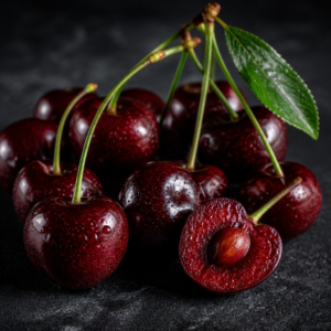 Fresh Spanish cherries on dark marble — deep crimson fruit with green stems